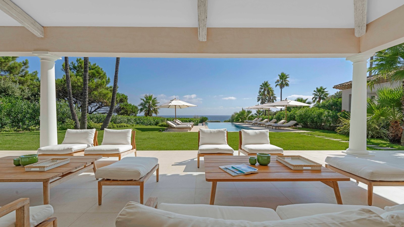 Salon extérieur ouvert sur la piscine et la mer